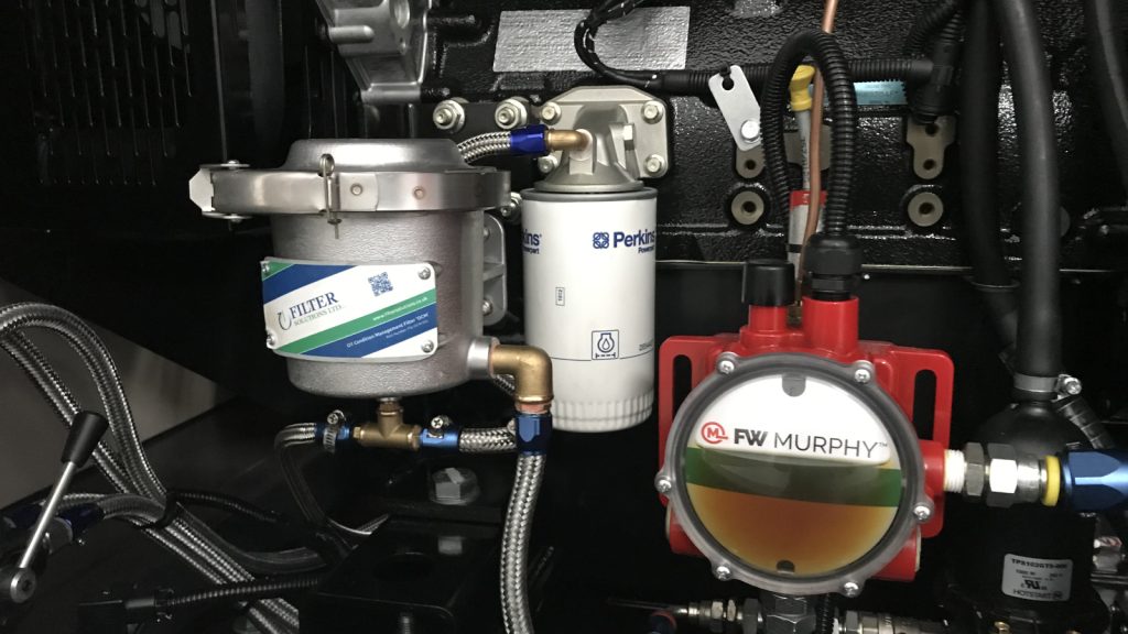 OCM bypass oil filter installed alongside the original Perkins full-flow oil filter on an industrial diesel engine